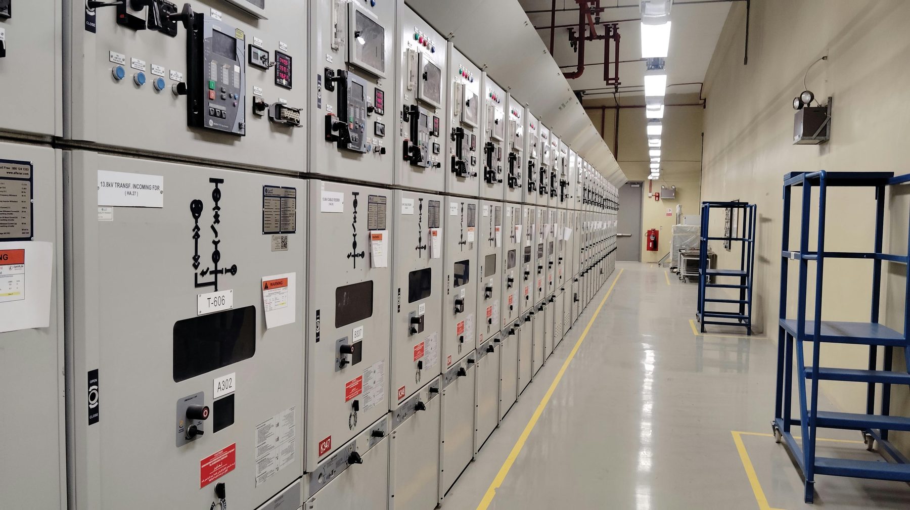 Long row of electrical switchgear panels in a clean control room